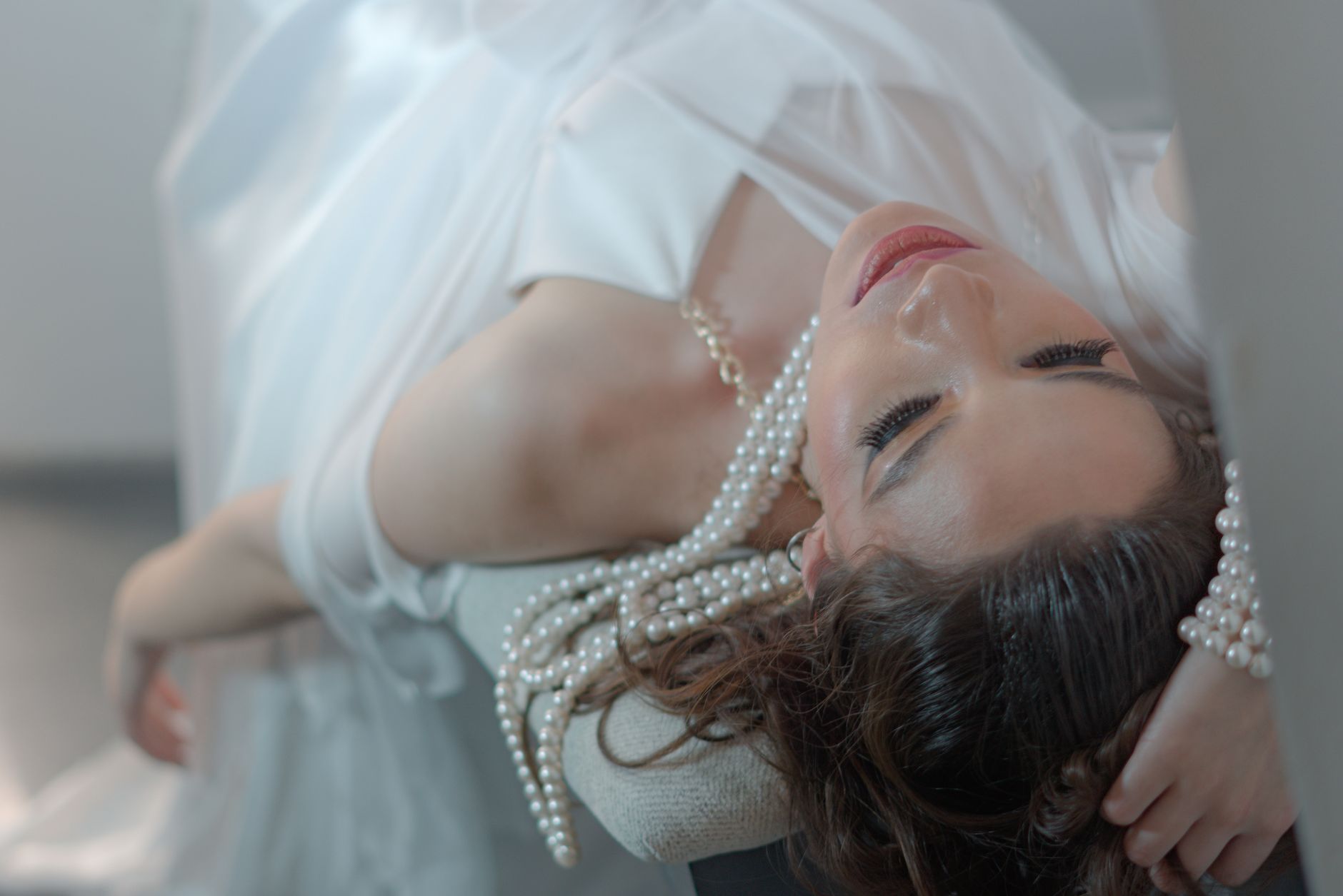 A woman in a white dress with pearl accessories reclines gracefully indoors. — How Bscscan Enhances Your Cryptocurrency Exper