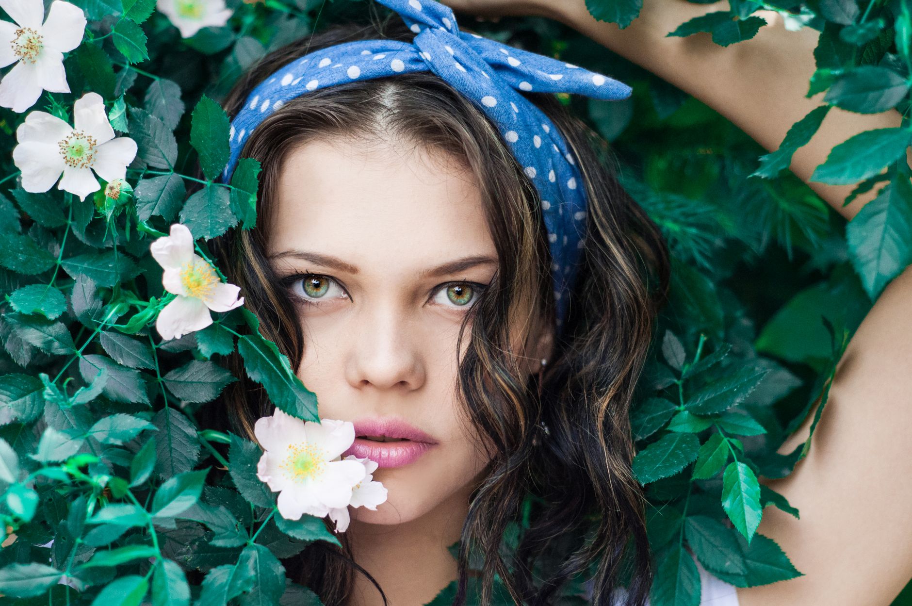 Young woman with polka dot headband surrounded by lush green leaves and white flowers. — How Bscscan Simplifies Blockchain Ma