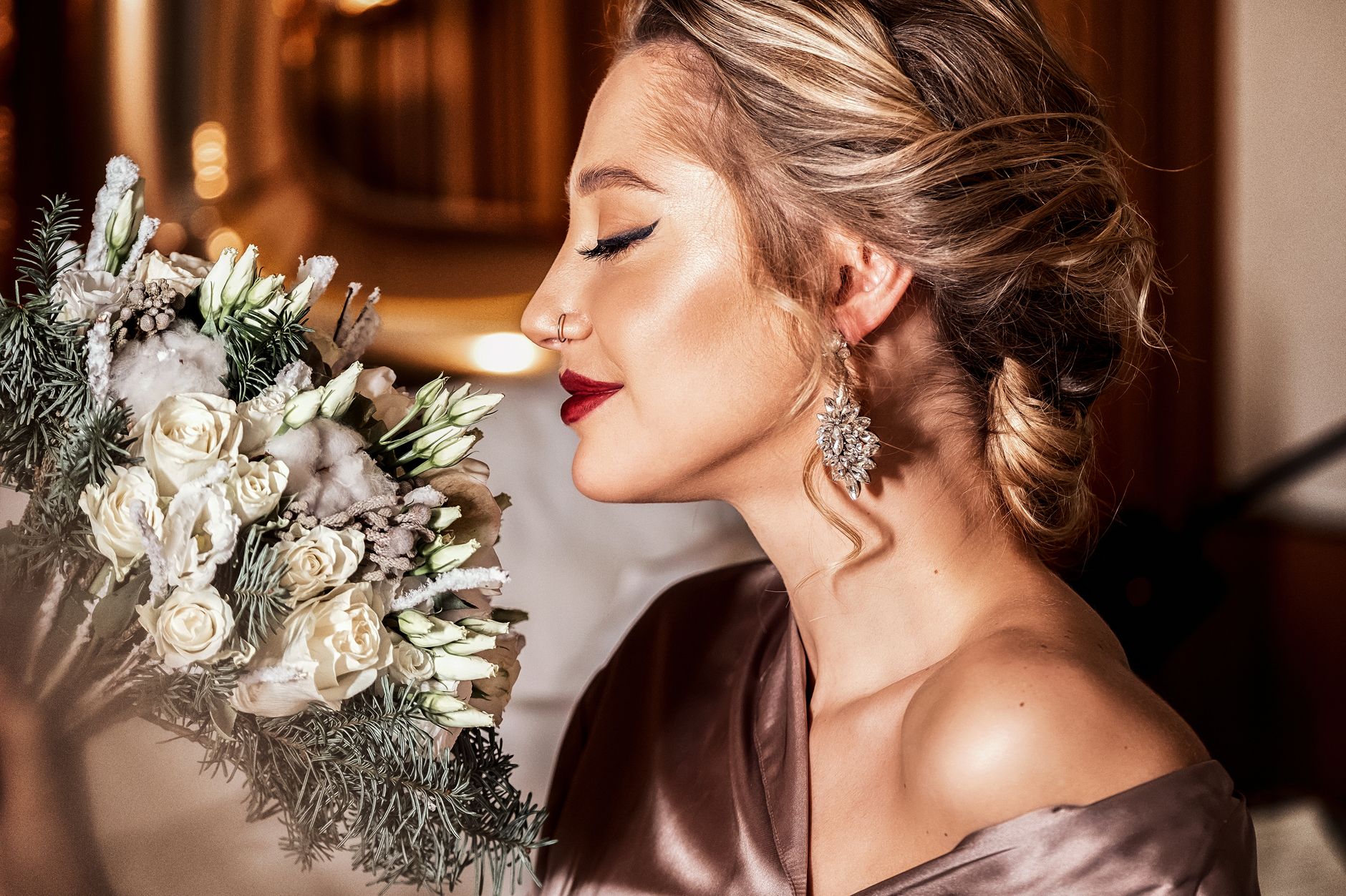 A stylish woman in an elegant dress enjoys the scent of a floral bouquet indoors. — Suositeltu Pay N Play -opas: Kuinka pelat